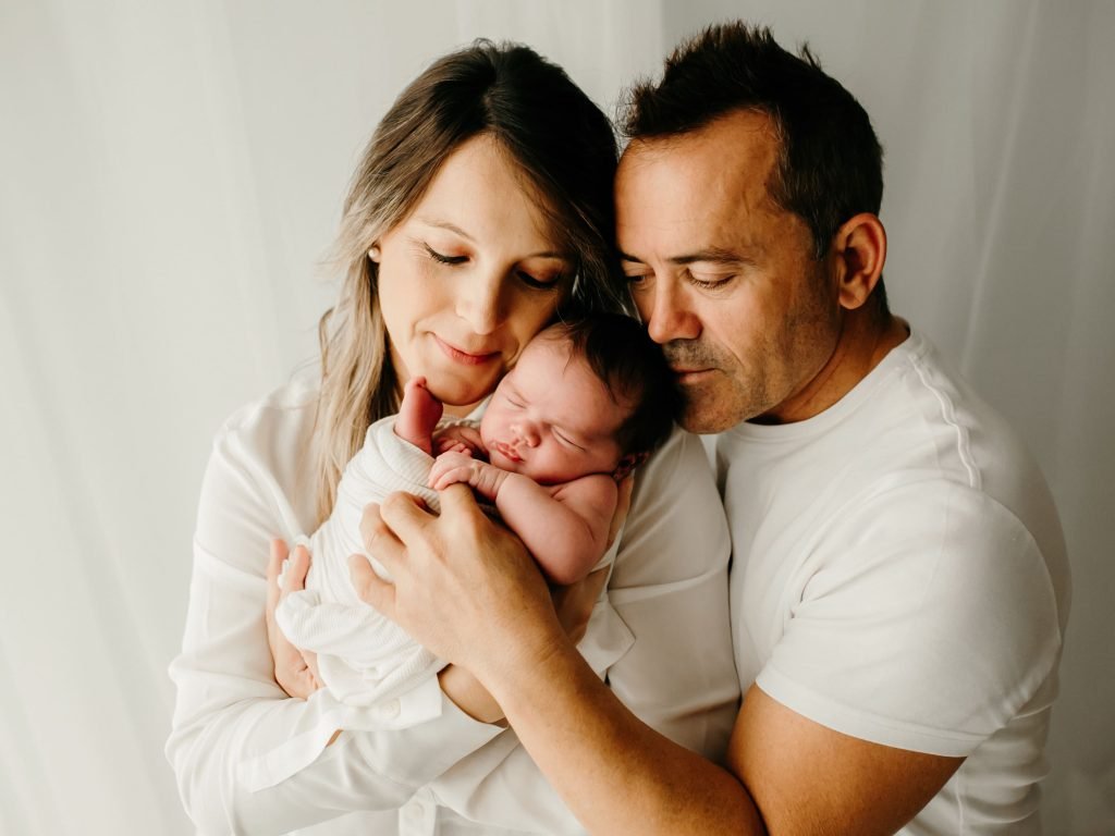 Padres sosteniendo a su bebé recién nacido en una sesión de fotografía newborn natural